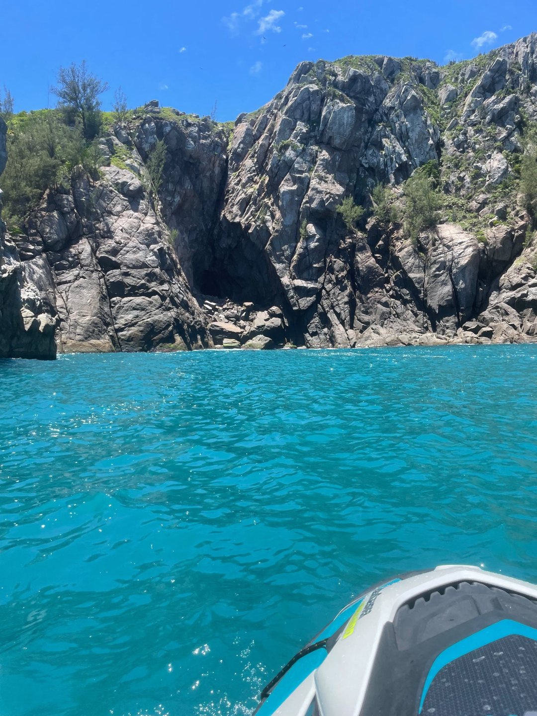 Proa do Jet Ski em água turquesa junto ao costão rochoso de Arraial do Cabo